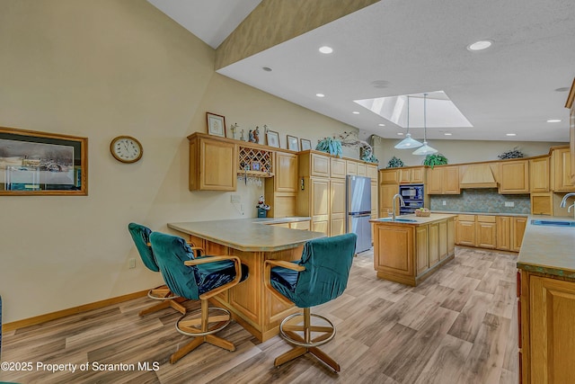 1742 State Route 848, New Milford, PA 18834 - kitchen with a skylight, freestanding refrigerator, high vaulted ceiling, black microwave, and a kitchen island with sink
