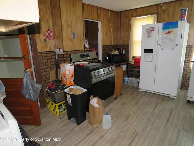 kitchen featuring light hardwood / wood-style flooring, brick wall, range with gas cooktop, and white refrigerator with ice dispenser