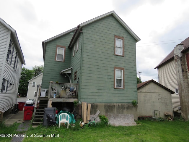 back of property featuring a lawn and a shed