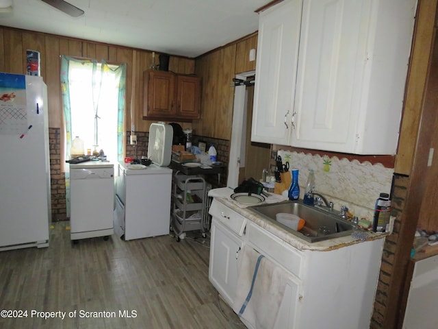 kitchen featuring white cabinetry, sink, light hardwood / wood-style flooring, independent washer and dryer, and white appliances