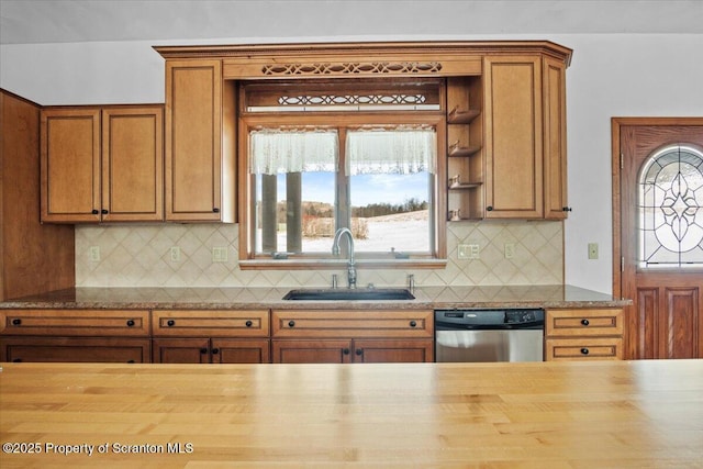 kitchen with stainless steel dishwasher, wood counters, sink, and a wealth of natural light