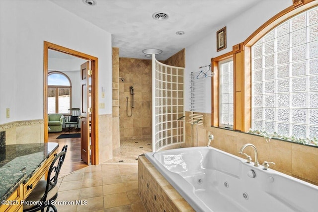 bathroom with tile walls, tile patterned floors, and shower with separate bathtub