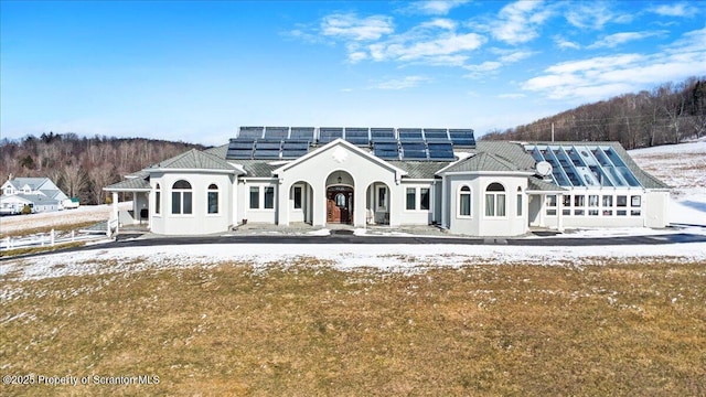 snow covered property featuring a yard and solar panels