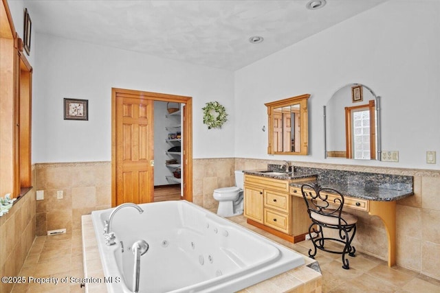 bathroom with tile walls, tiled tub, and toilet