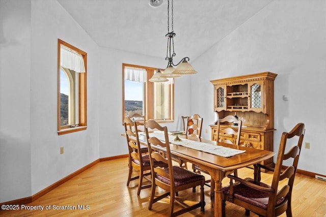 dining room with lofted ceiling and light wood-type flooring