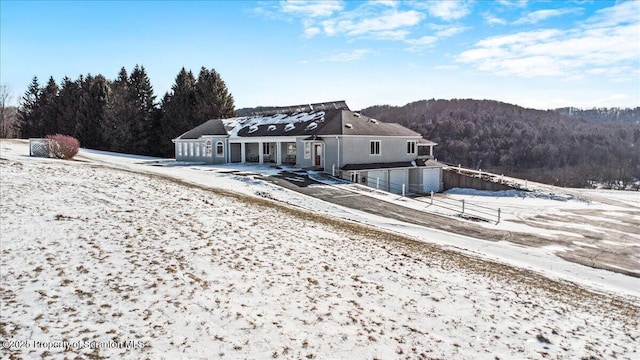 snow covered house featuring a mountain view