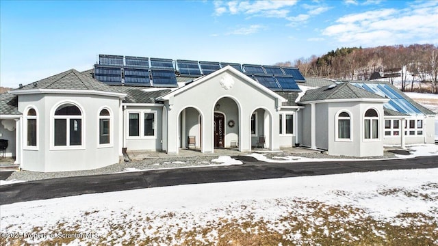 snow covered rear of property with solar panels