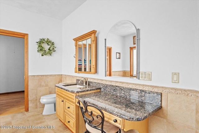 bathroom featuring vanity, tile walls, tile patterned floors, and toilet