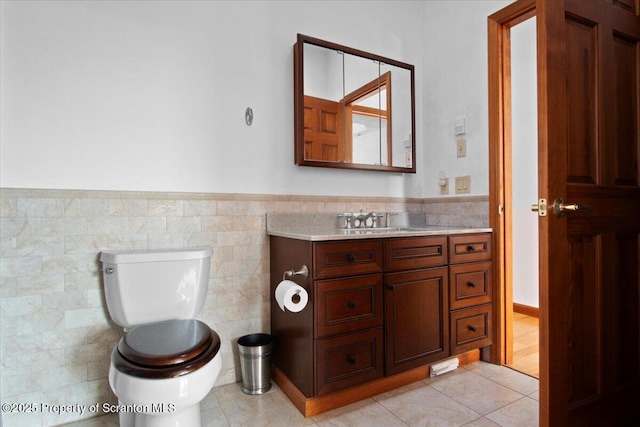 bathroom featuring vanity, tile walls, tile patterned floors, and toilet