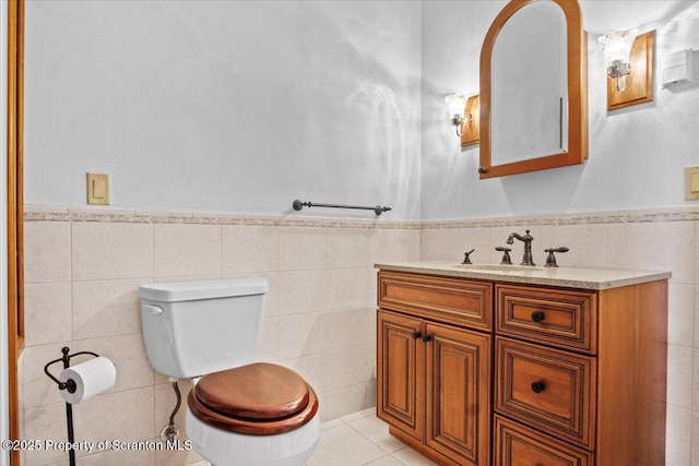 bathroom featuring tile patterned floors, vanity, toilet, and tile walls