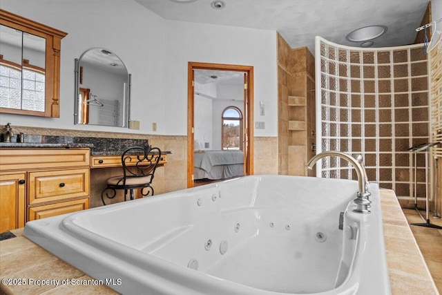 bathroom featuring vanity, tile walls, and a relaxing tiled tub