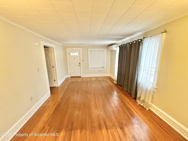 entryway featuring hardwood / wood-style floors, crown molding, and a wall mounted AC