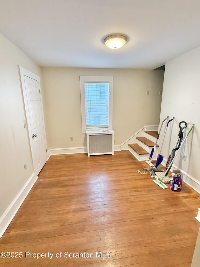 empty room featuring radiator and hardwood / wood-style floors