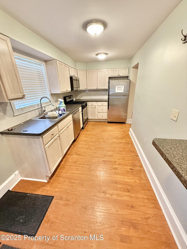 kitchen featuring appliances with stainless steel finishes, light hardwood / wood-style flooring, and sink