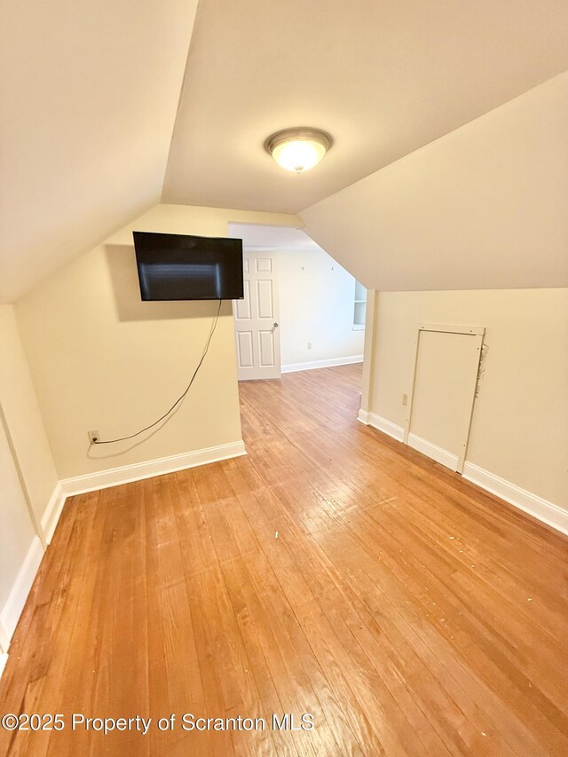 interior details featuring light brown cabinetry, decorative backsplash, hardwood / wood-style floors, and stainless steel range with gas cooktop