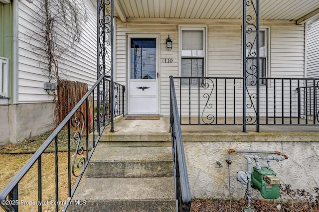 view of exterior entry featuring covered porch