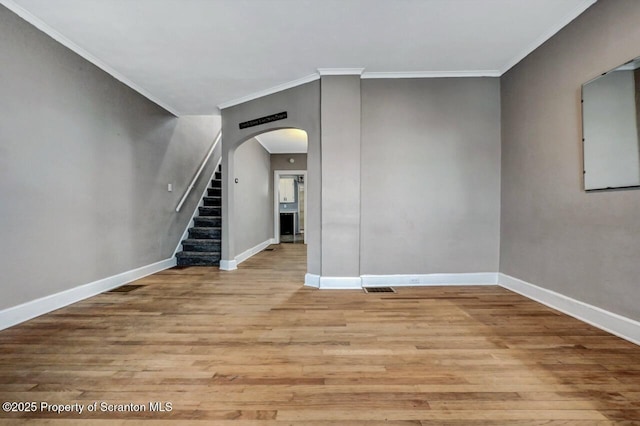 unfurnished room featuring visible vents, baseboards, wood finished floors, and crown molding
