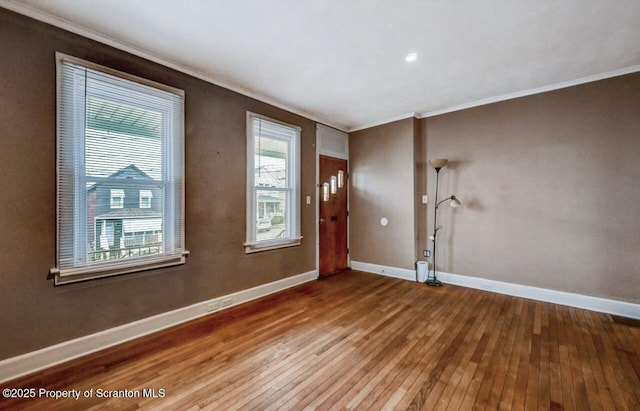 entrance foyer with baseboards, wood-type flooring, and ornamental molding