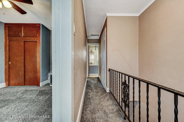 corridor featuring carpet, baseboards, and ornamental molding