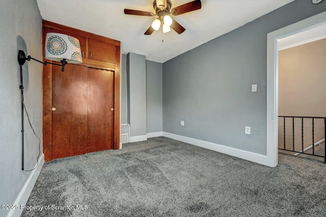 unfurnished bedroom with baseboards, carpet, and a ceiling fan