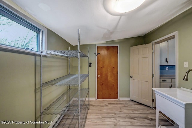 interior space with cabinet space, baseboards, and light wood finished floors