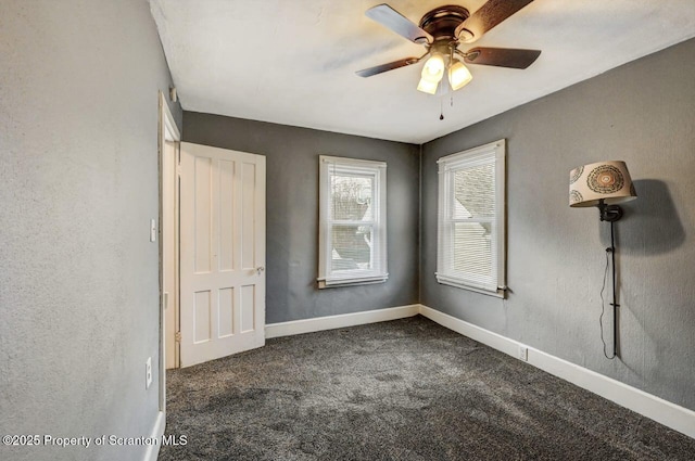 unfurnished bedroom with a ceiling fan, baseboards, and dark colored carpet