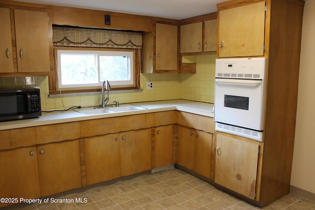 205 Orchard St, Old Forge, PA 18518 - kitchen featuring stainless steel microwave, white oven, decorative backsplash, and light countertops
