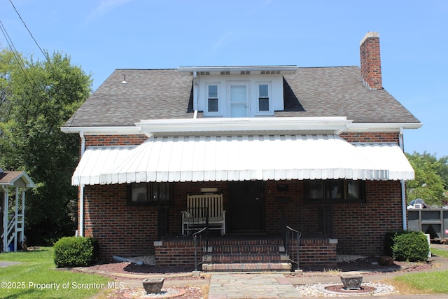 205 Orchard St, Old Forge, PA 18518 - view of front facade featuring a porch, brick siding, a chimney, and a shingled roof