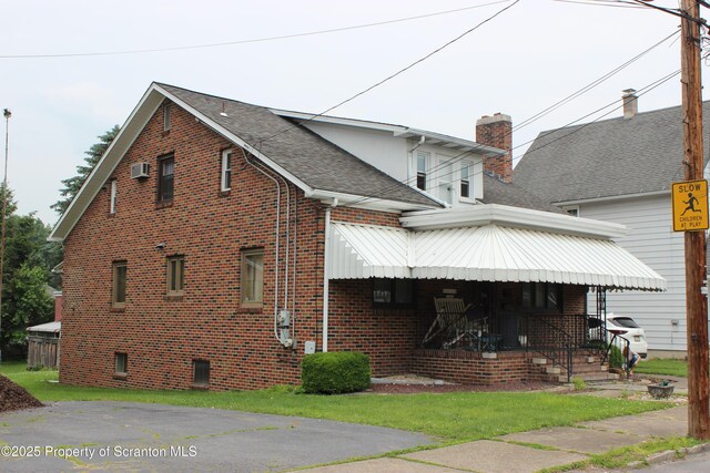 205 Orchard St, Old Forge, PA 18518 - view of property exterior with a porch, brick siding, a shingled roof, and a chimney