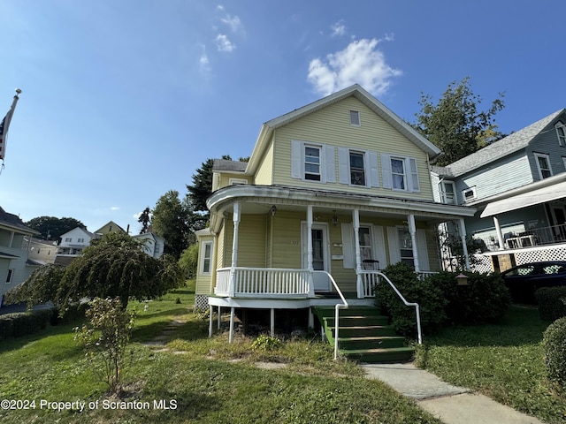 view of front of house with a front yard and a porch