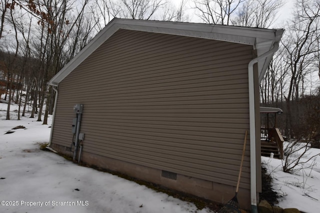 view of snow covered exterior with crawl space