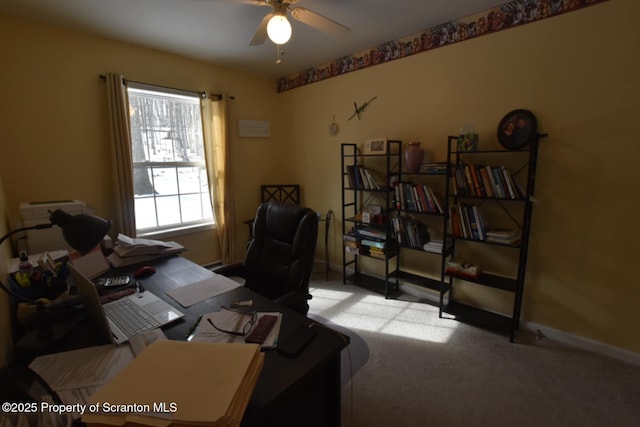 office space with light colored carpet, ceiling fan, and baseboards