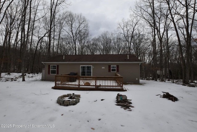 snow covered property featuring a fire pit and a deck