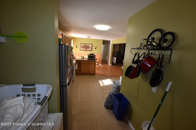 kitchen featuring brown cabinetry and freestanding refrigerator