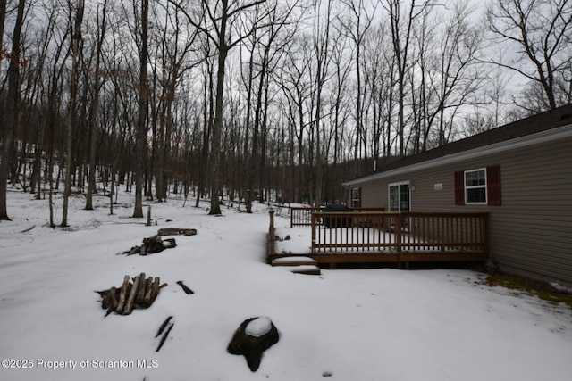 yard layered in snow featuring a wooden deck