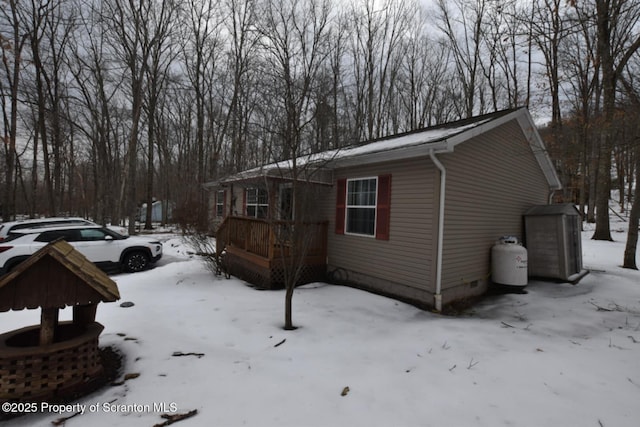 view of snow covered exterior featuring a wooden deck