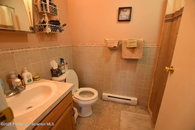 bathroom with toilet, a baseboard heating unit, vanity, tile walls, and tile patterned floors