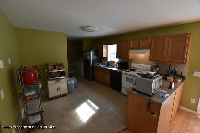 kitchen with under cabinet range hood, stainless steel appliances, a peninsula, baseboards, and brown cabinets