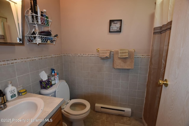 bathroom featuring baseboard heating, vanity, toilet, and tile walls