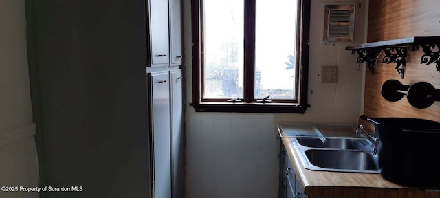 kitchen featuring wooden walls and sink