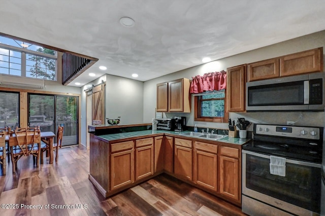 482 Lakeview Dr, Kingsley, PA 18826 - kitchen with appliances with stainless steel finishes, a peninsula, a sink, brown cabinets, and dark wood-style flooring