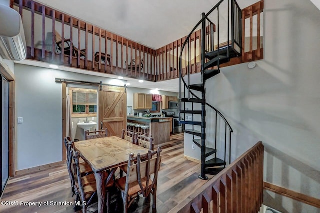 482 Lakeview Dr, Kingsley, PA 18826 - dining room with light wood finished floors, a barn door, stairway, and a towering ceiling