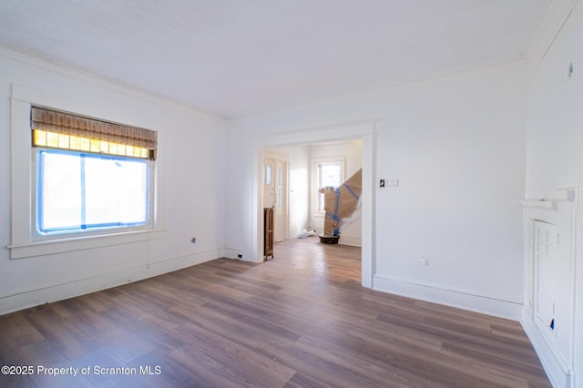 unfurnished room with baseboards, ornamental molding, and wood finished floors