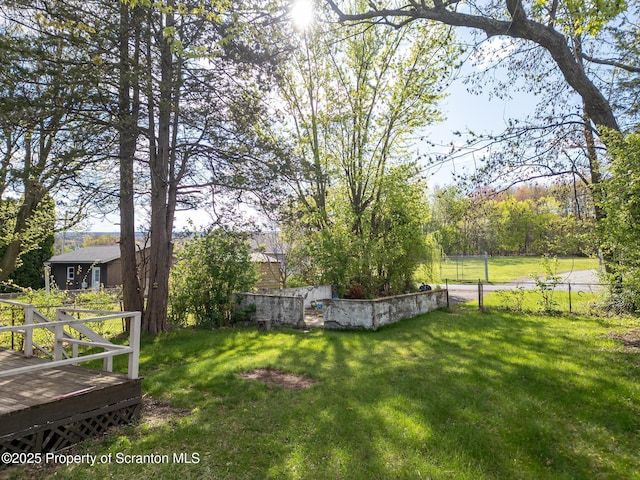 view of yard featuring fence and a deck