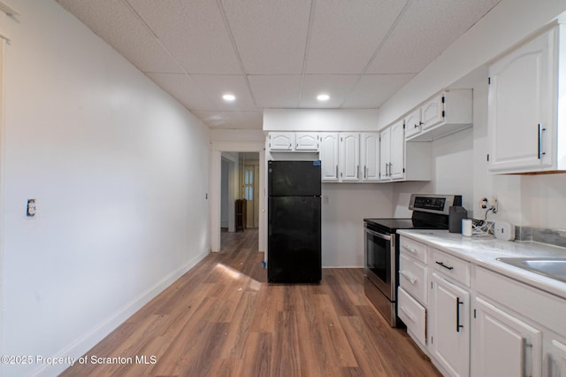 kitchen with freestanding refrigerator, electric range, recessed lighting, white cabinets, and light wood-style flooring