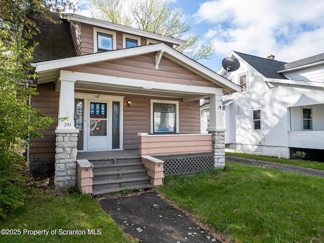 bungalow featuring a porch and a front lawn