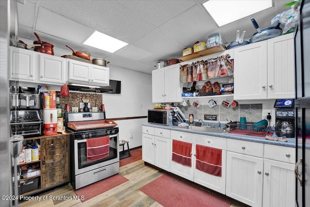 kitchen with stainless steel electric stove, a paneled ceiling, sink, and tasteful backsplash