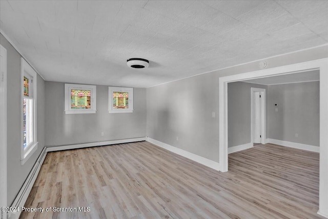 unfurnished room with a wealth of natural light, light hardwood / wood-style flooring, and baseboard heating