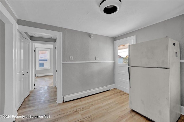 kitchen featuring white fridge, a healthy amount of sunlight, a baseboard radiator, and light hardwood / wood-style floors