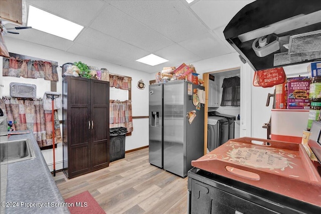 kitchen with a drop ceiling, sink, separate washer and dryer, light hardwood / wood-style flooring, and stainless steel fridge with ice dispenser